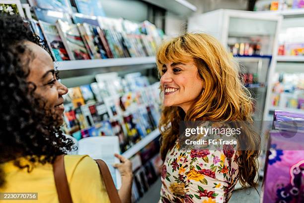 friends women talking on bookstore - news stand stock pictures, royalty-free photos & images