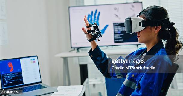 young female engineer using virtual reality to design and control robotics arm in tech lab. smart glasses analyze, and simulate ai and automated systems. ai and robotics development. - computer simulation stock pictures, royalty-free photos & images