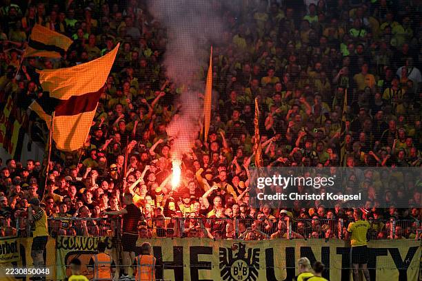 Fans of Borussia Dortmund fire pyrotechnic during the DFB Cup match between Rot-Weiss Essen and Borussia Dortmund at Stadion an der Hafenstrasse on...