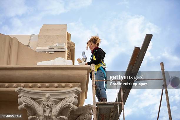 female artist restoring the facade of a renaissance building - restoring stock pictures, royalty-free photos & images