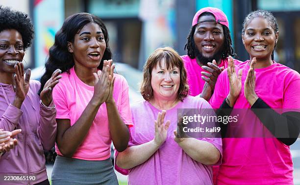 group of friends in pink at breast cancer awareness event - maschio con gruppo di femmine foto e immagini stock