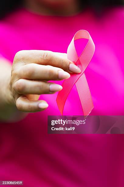 breast cancer awareness ribbon in woman's hand - cancer awareness ribbon stock pictures, royalty-free photos & images