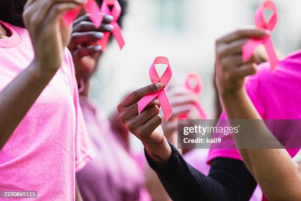 rubans de sensibilisation au cancer du sein dans les mains des femmes - sensibilisation au cancer du sein photos et images de collection