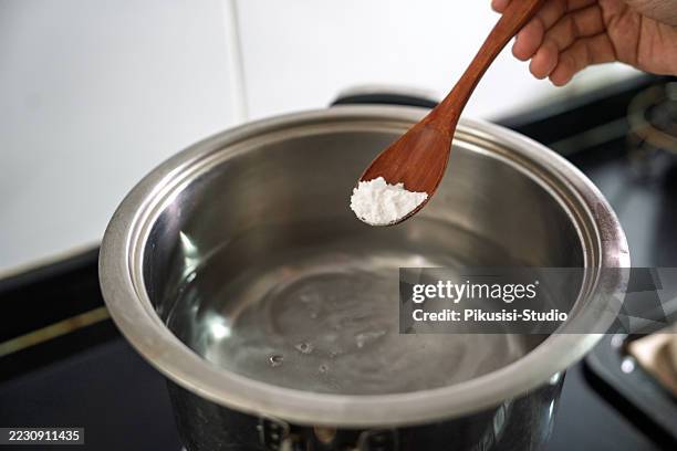 agregar bicarbonato de sodio en agua hirviendo para la preparación del bagel - hervir fotografías e imágenes de stock