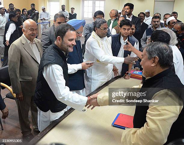 Rahul Gandhi, accompanied by former Prime Minister Manmohan Singh, greets the returning officers at the All India Congress Committee office in New...