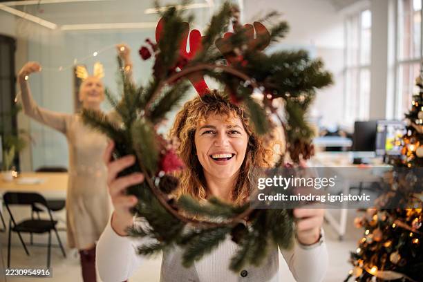 women colleagues creating festive workplace - festieve stemming stockfoto's en -beelden