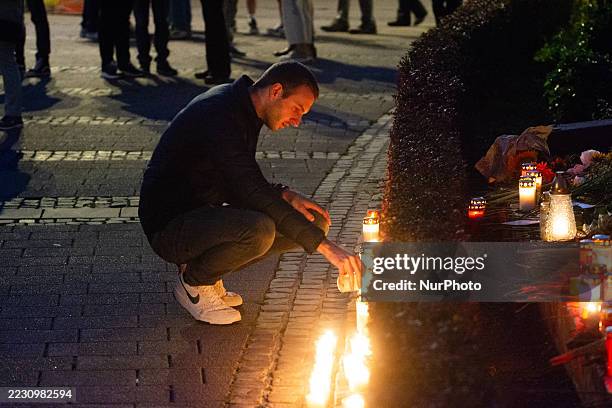 Man lights the candle in front of the memorial stone at Stadtkirche am Fronhof in Solingen during the candlelight service on the anniversary of the...