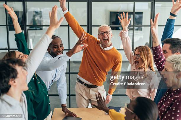 diverse team celebrating success together - cheering stock pictures, royalty-free photos & images