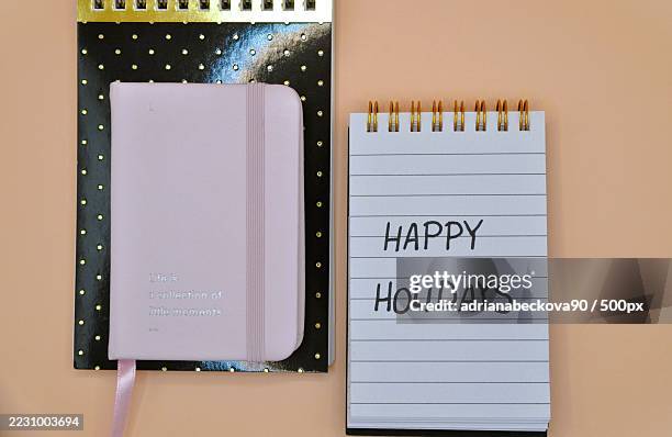 overhead view of notebooks with holiday message on a peach background - table font view stock pictures, royalty-free photos & images