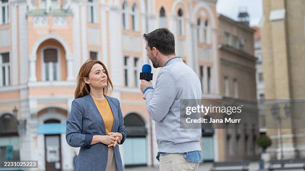 momento sincero durante una entrevista en una animada escena urbana. - entrevista con medio de comunicación fotografías e imágenes de stock