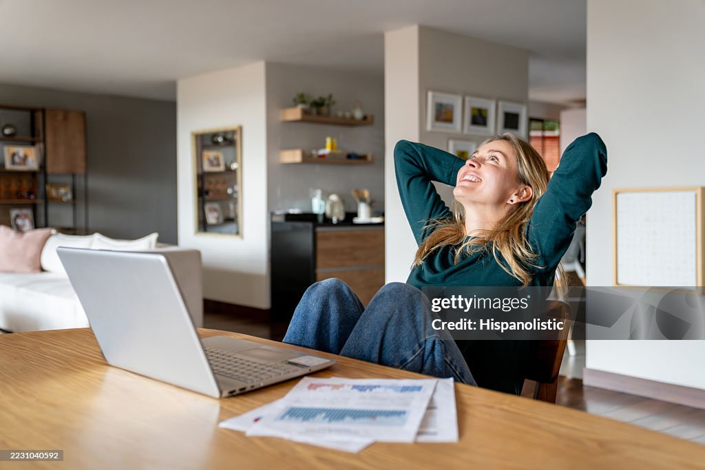 Donna che lavora a casa e si appoggia all'indietro mentre fa una pausa
