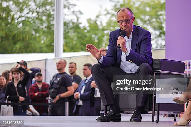 German Chancellor Friedrich Merz speaks to visitors during open house day at the Chancellery on August 24, 2025 in Berlin, Germany. A number of...