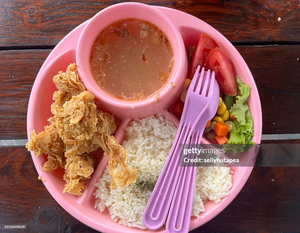 Colorful Kids Meal with Fried Chicken, Rice, Vegetables, and Soup in Pink Plate