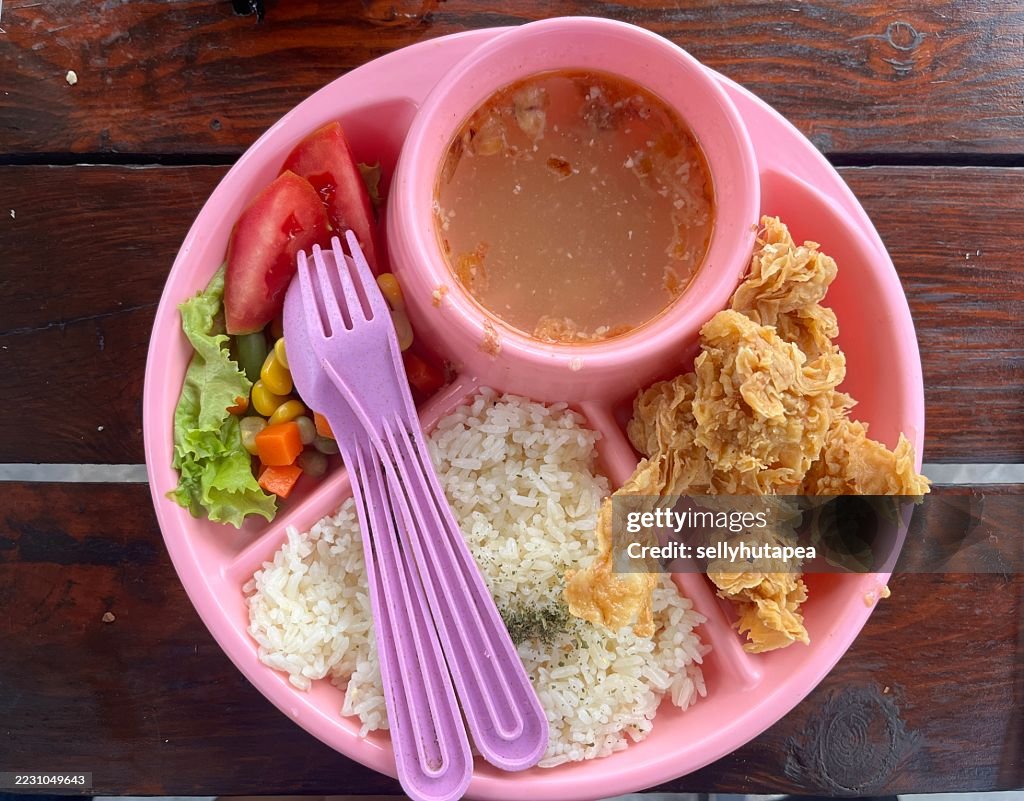 Colorful Kids Meal with Fried Chicken, Rice, Vegetables, and Soup in Pink Plate