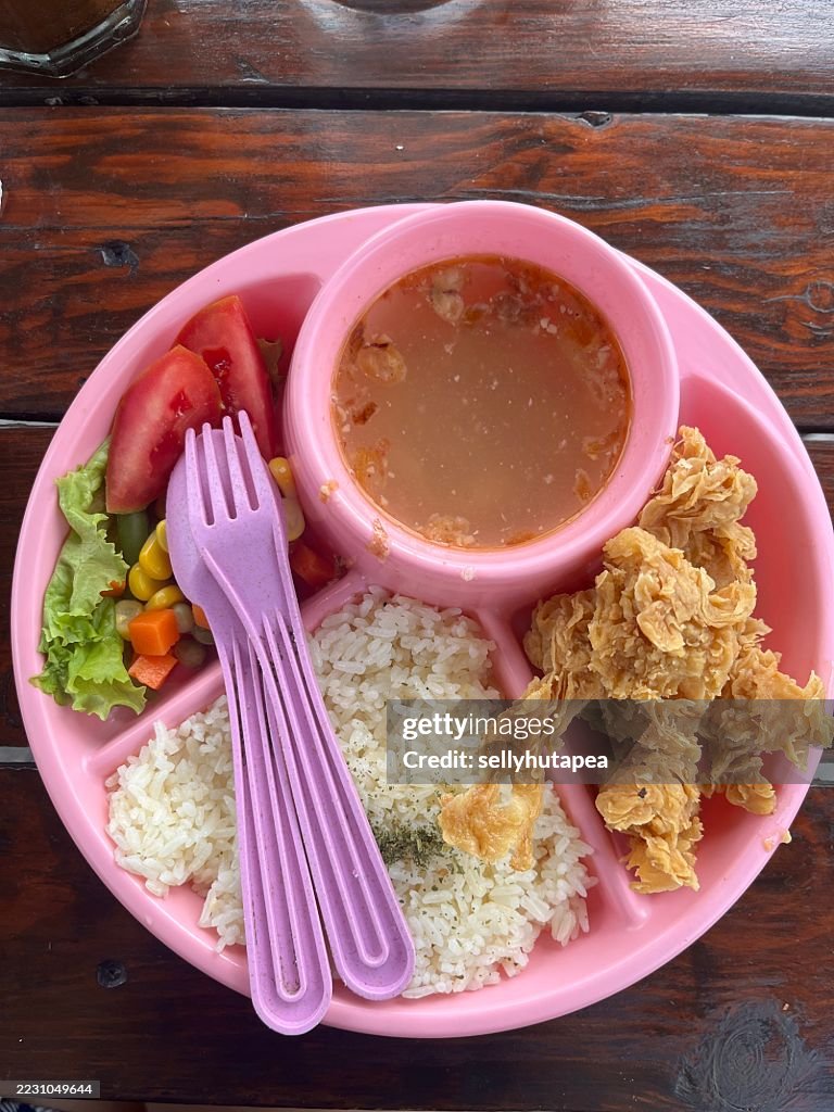 Colorful Kids Meal with Fried Chicken, Rice, Vegetables, and Soup in Pink Plate