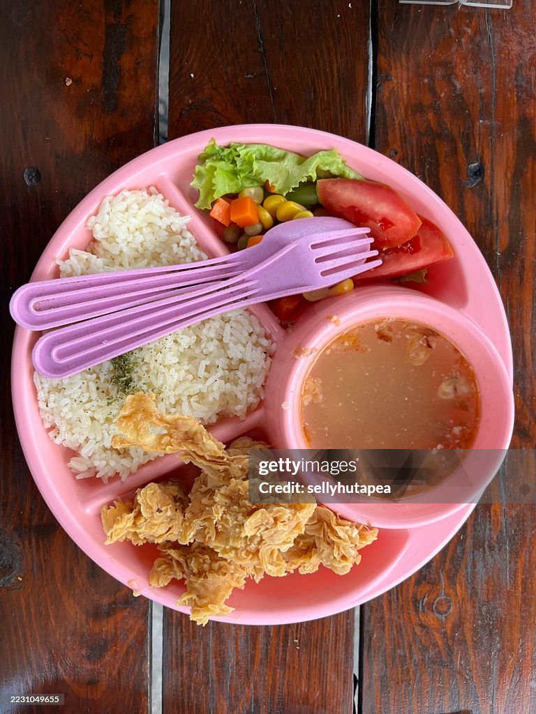 Colorful Kids Meal with Fried Chicken, Rice, Vegetables, and Soup in Pink Plate