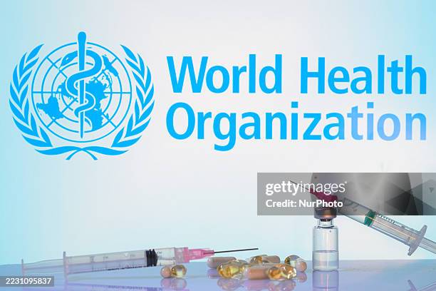 The World Health Organization seal is seen on a screen with tablets, capsules, and syringes in this photo illustration in Brussels, Belgium, on...