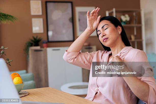 mature woman experiencing hot flash and headache - symptom stock pictures, royalty-free photos & images