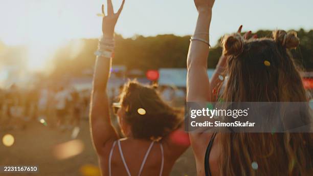 young caucasian women celebrating at outdoor music festival - traditional festival stock pictures, royalty-free photos & images