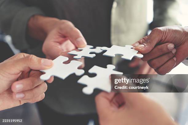 gruppe von geschäftsleuten, die ein puzzleteil in der hand halten. fusionskonzept für die integration von geschäftslösungen. - koordination stock-fotos und bilder