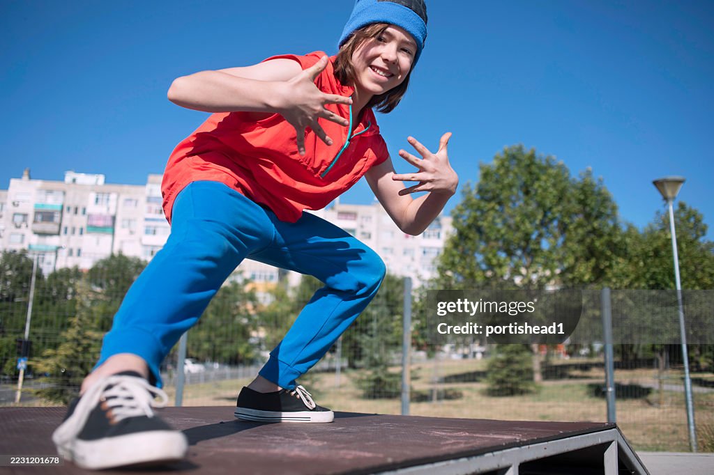Energetic boy dancing break and hip hop on skate ramp