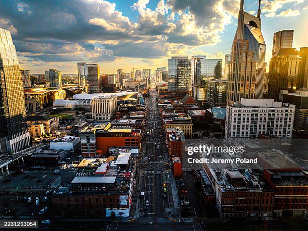 dramatischer himmel über dem broadway in downtown nashville, tennessee, an einem sonnigen sommernachmittag von der nordseite des cumberland river in der nähe des nissan-stadions - nissan stadium nashville stock-fotos und bilder