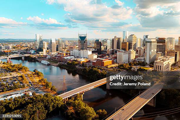 elevated view of james robertson parkway & woodland street bridges in downtown nashville, tennessee on a sunny summer afternoon from the north side of the cumberland river near nissan stadium - nashville stockfoto's en -beelden