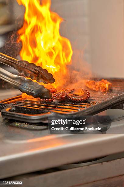chef grilling octopus in flames at peruvian restaurant - burnt dinner stock pictures, royalty-free photos & images