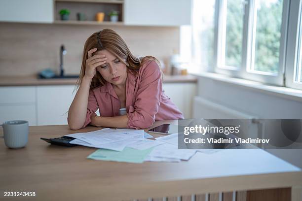 stressed young woman having financial problems at home - struggle stock pictures, royalty-free photos & images