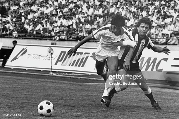 Newcastle's Kevin Keegan holds the arm of Japan's Akihiro Nishimura during a Japan Cup match at the National Stadium in Tokyo, Japan, May 29th 1983....