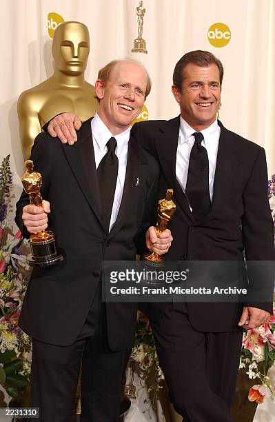 Ron Howard, winner in the Best Director and Best Picture categories for A Beautiful Mind, poses with presenter Mel Gibson for photographers backstage...