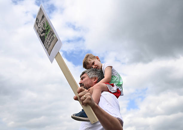 Young boy and his father join fellow Lough Neagh activists attending a Save The Lough rally at Lough Neagh on August 25, 2025 in Antrim, Northern...