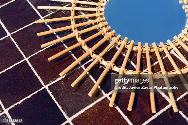 decorative mirror with bamboo frame reflecting blue sky on tiled surface - enamel surface stock pictures, royalty-free photos & images