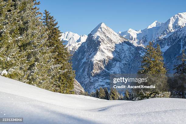 aerial view of snow covered ski hill at sunrise, swiss alps - swiss alps stock pictures, royalty-free photos & images