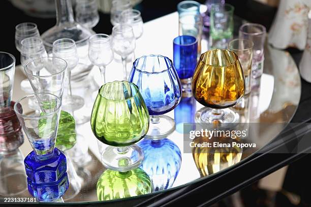 vintage crystal wineglasses and retro shot glasses against mirror background at the local flea market - crystal glassware stock pictures, royalty-free photos & images
