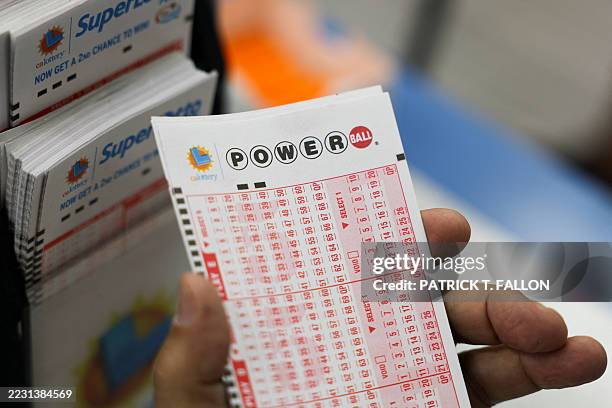 Customer holds a number slip for Powerball lottery tickets for a $750 Million grand prize jackpot inside the Bluebird Liquor Store, which has sold...