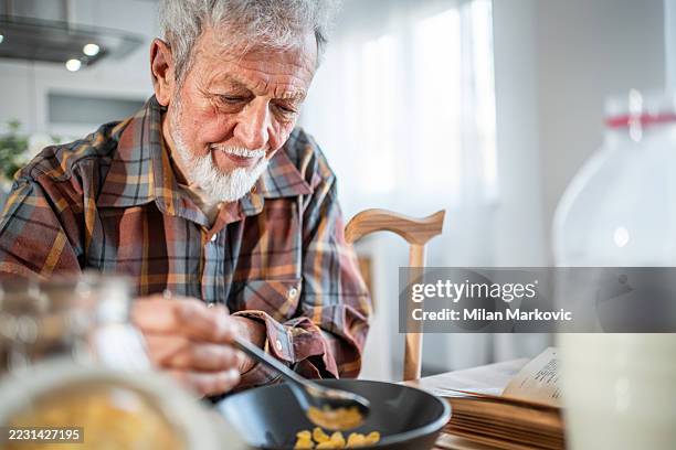 älterer mann genießt ein gesundes frühstück zu hause - einzelner senior stock-fotos und bilder