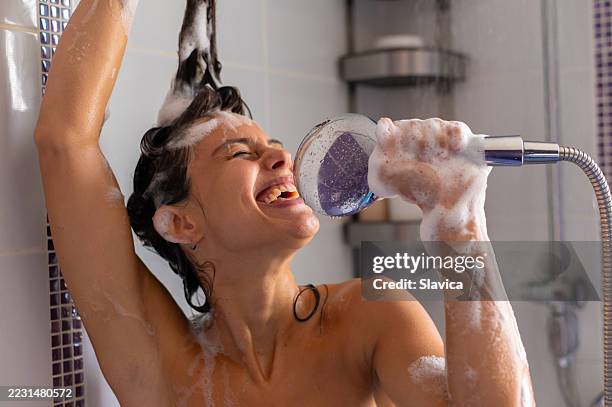 happy young woman taking a shower and singing - human body part stock pictures, royalty-free photos & images