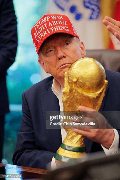 President Donald Trump holds the World Cup Trophy in the Oval Office August 22, 2025 in Washington, DC. Trump announced the FIFA World Cup 2026 draw...