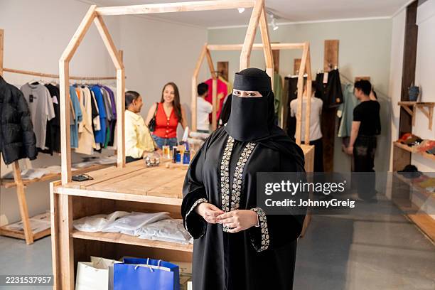 retrato de una mujer de oriente medio con burka en una tienda de ropa moderna - encuadre cintura para arriba fotografías e imágenes de stock