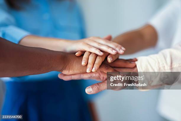 group of individuals joining hands to represent unity and collaboration - lealdade imagens e fotografias de stock