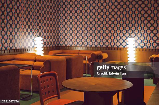 retro lounge interior with patterned wallpaper and warm lighting - estilo moderno de meados do século imagens e fotografias de stock