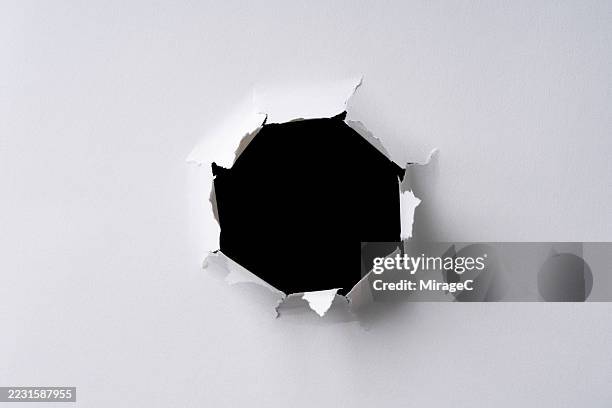 circular bullet hole in white paper - trou photos et images de collection