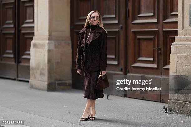Sonia Lyson seen wearing Miu Miu rectangular tinted sunglasses with slim metallic frames, Ducie brown suede belted jacket featuring a zip closure,...