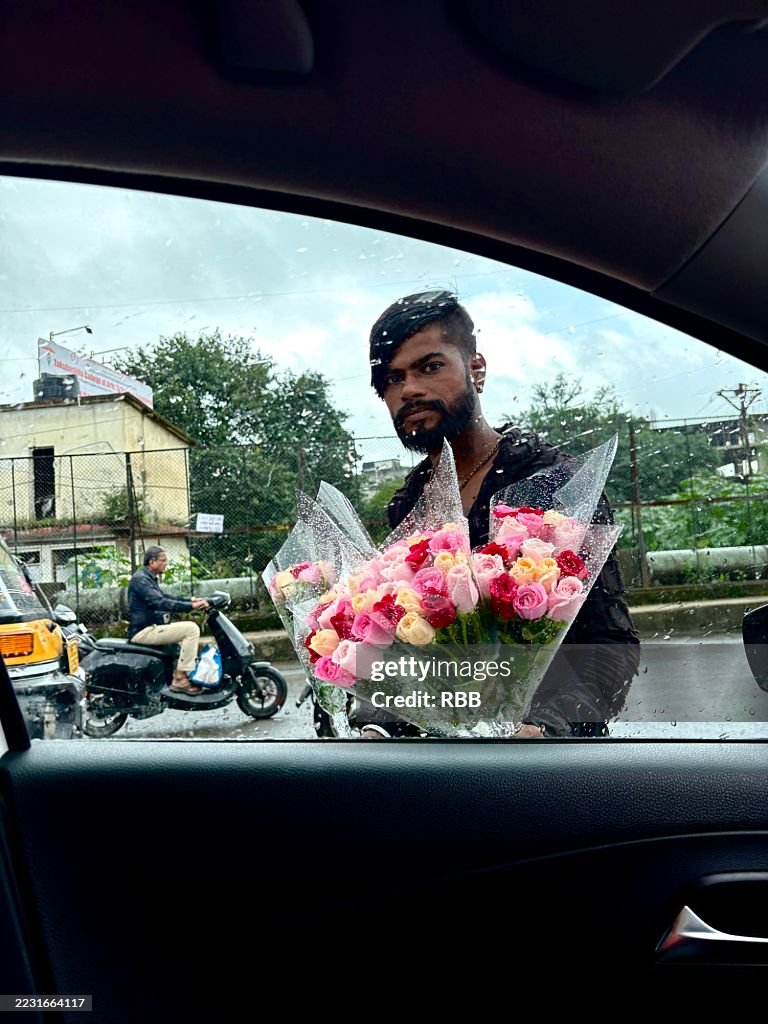 A flower seller viewed through car window in Pune city.