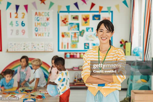 happy elementary school teacher smiling in the classroom - nanny stock pictures, royalty-free photos & images