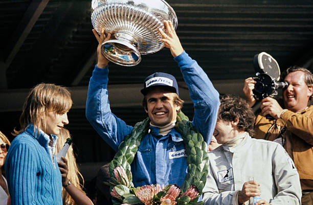 Carlos Reutemann celebrates victory on the podium with his trophy. Jean-Pierre Beltoise, 2nd position, is on the right during the South African GP at...