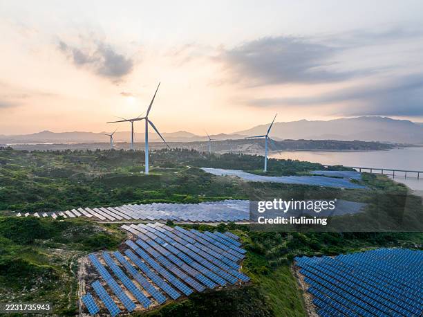 solar and wind farms at dusk - fábricas tradicionales fotografías e imágenes de stock