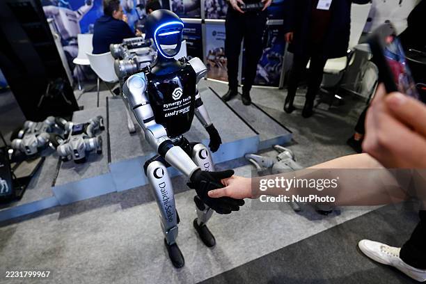 The Unitree H1, one of the two biped humanoid robots developed by the Chinese robotics company, shakes hands with a congress assistant during the...