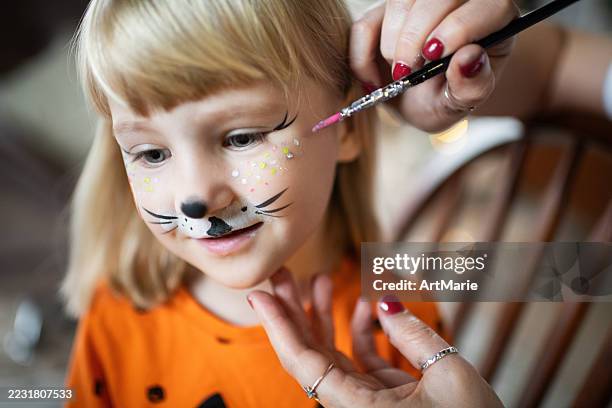 niña feliz preparándose para halloween - pintura de cara fotografías e imágenes de stock